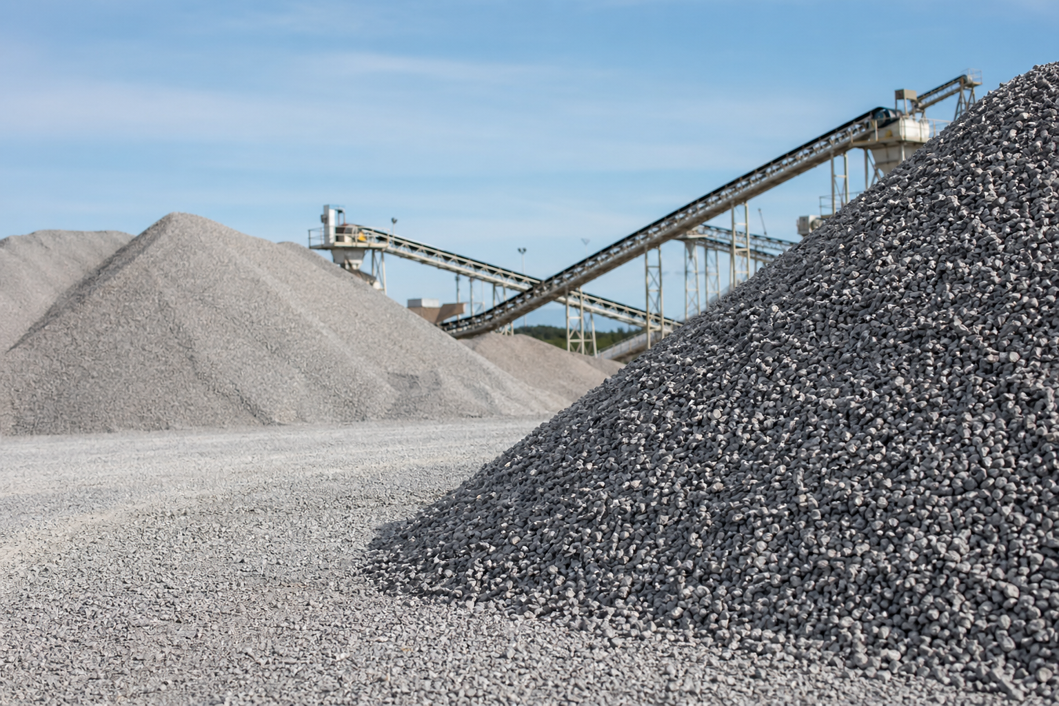 Crushed stone and aggregate stockpiles for construction procurement.